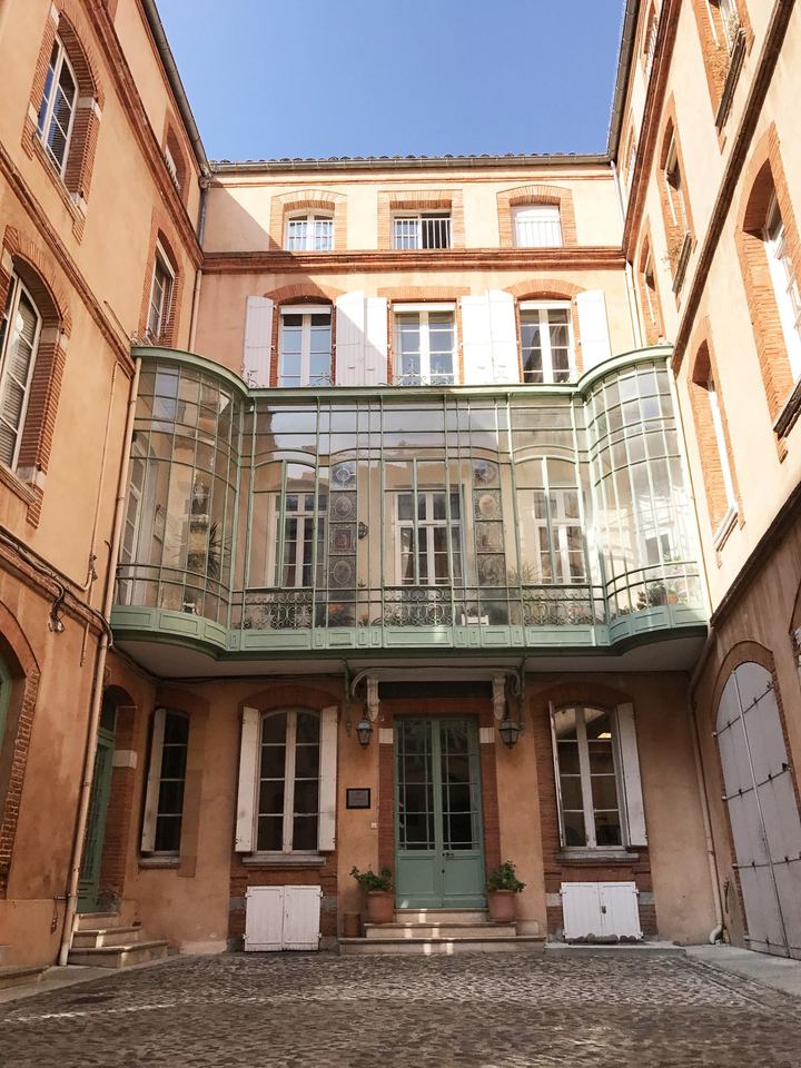 Cour intérieure d’une copropriété toulousaine, véranda et pavés