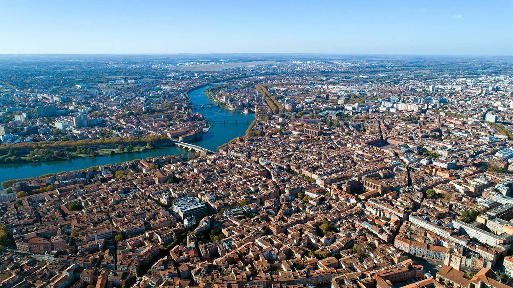 Vue aérienne de Toulouse : la Garonne, le Pont-Neuf et les toits de brique du centre ancien